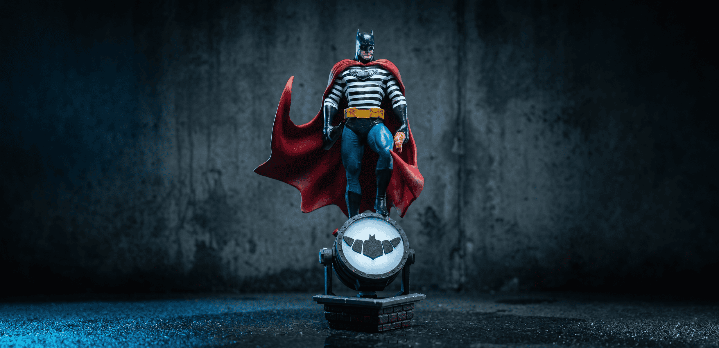 Detailed Batman figure with red cape standing on a circular base.