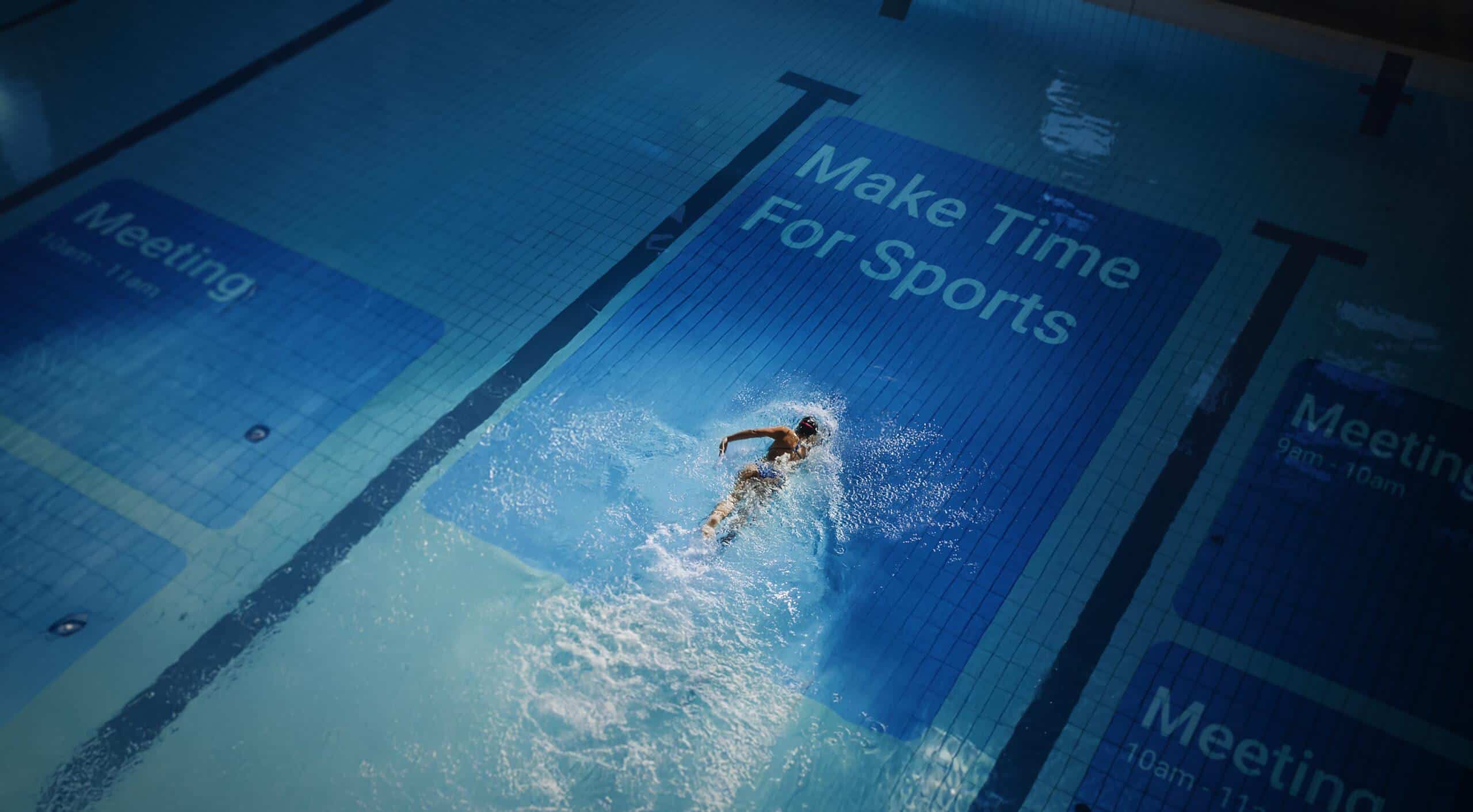 Swimmer diving into pool with "Make Time For Sports" sign in background.